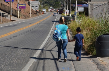 Mãe conduz o filho, aluno da creche, às margens da rodovia (Fotos: Henrique Pinheiro)