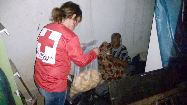 Distribuição de pães por voluntários da Cruz Vermelha nas madrugadas de Friburgo (Foto: Divulgação) 