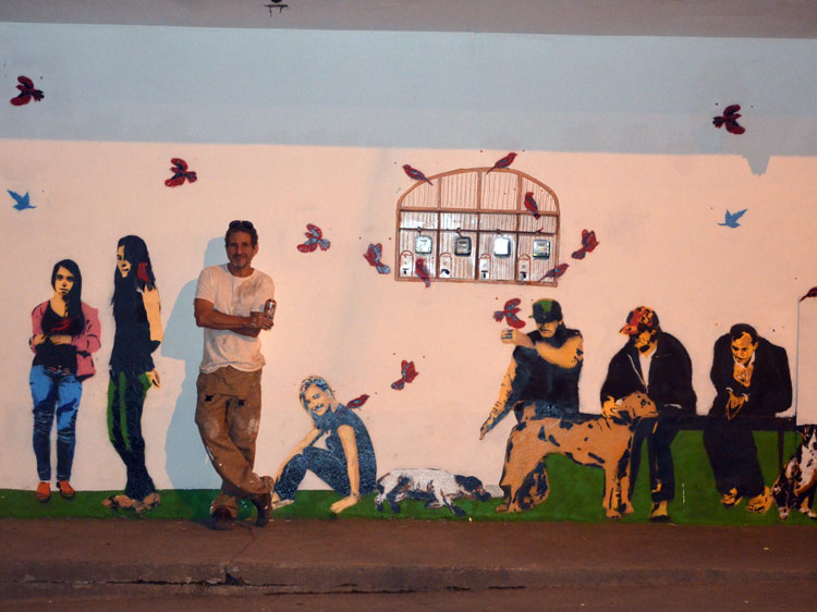O artista Andrea Brandani e personagens locais retratados num muro no centro de Lumiar (Foto: Andréa Rausch)