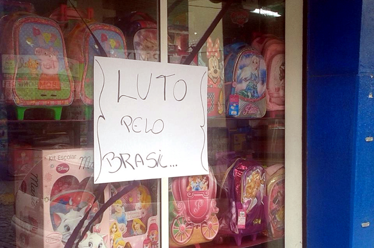 Nesta loja do centro,‭ ‬o cartaz afixado na vitrine sintetiza o que muitos empresários estão sentindo diante de uma crise que vem paralisando a economia‭ (Foto: Girlan Guilland)