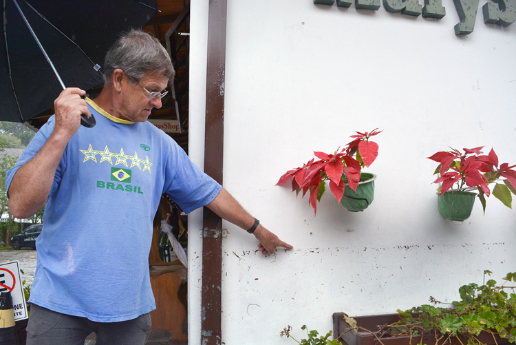 Morador de Mury mostra a altura que chegou a água (Foto: Henrique Pinheiro)