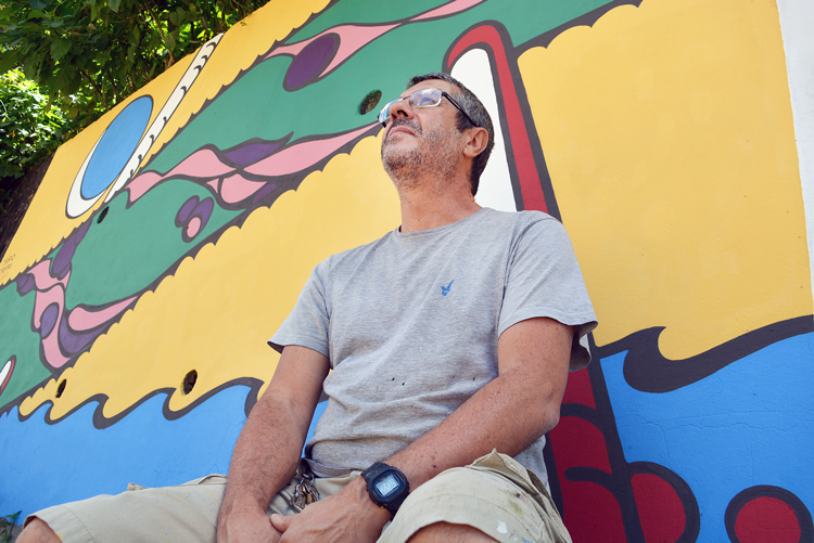 Mário Moreira e parte do muro já pintado (Foto: Henrique Pinheiro)