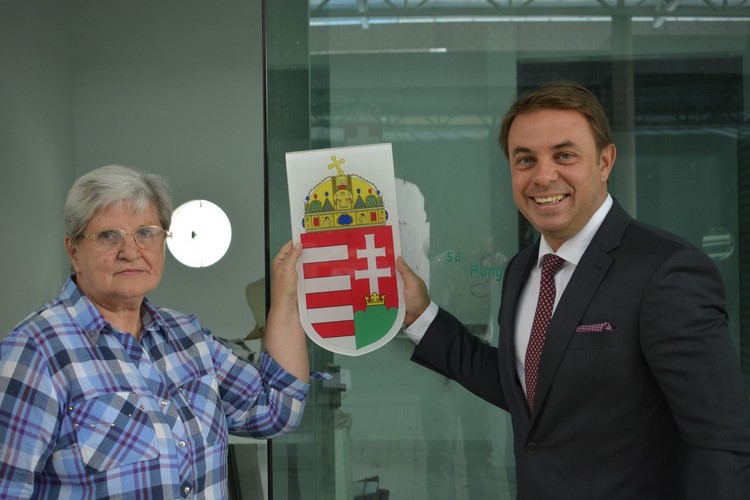 O embaixador  Norbert Konkoly e a presidente da Colônia Húngara em Friburgo, Eva Bito, mostram o brasão que será instalado no local (Foto: Henrique Pinheiro)