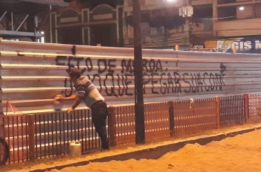 Funcionário limpa a pichação no tapume das obras na Estação Livre (Foto: Henrique Pinheiro)
