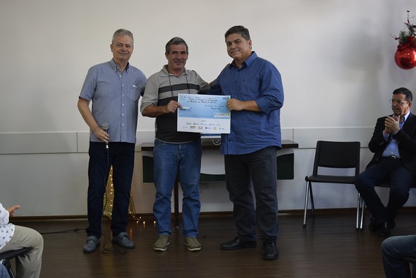O presidente do Comitê das Entidades Beneficentes de Nova Friburgo (Cebenf) recebe de Julio Cordeiro e Paulo Valente um cheque com as doações do Noel Bus (Divulgação)