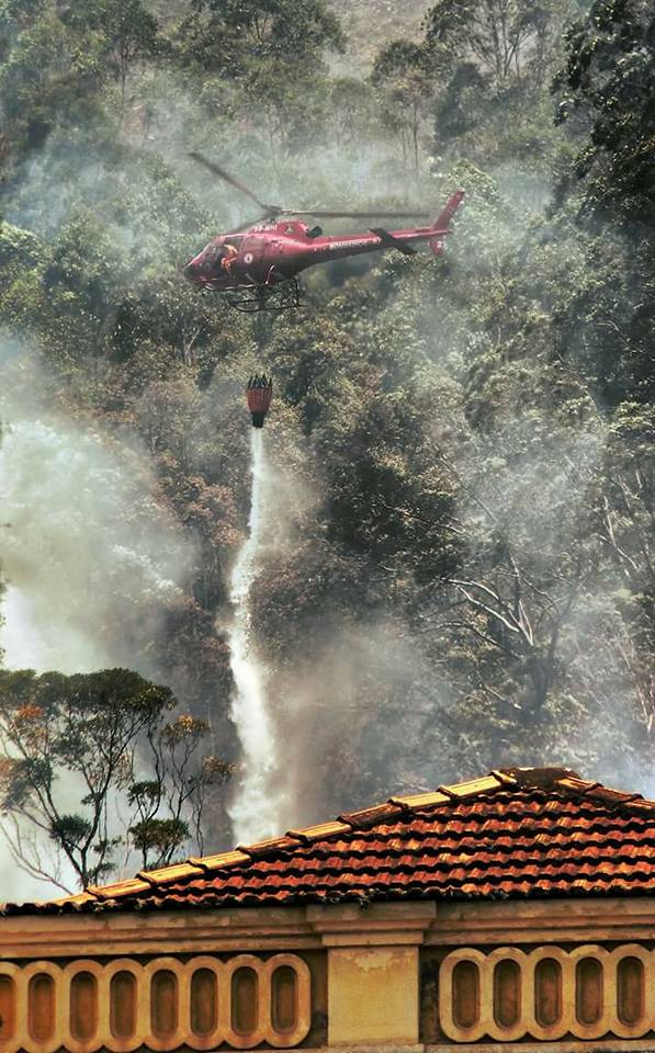 Helicóptero dos bombeiros joga água na mata em chamas atrás do Anchieta (Foto: Antônio Varella)