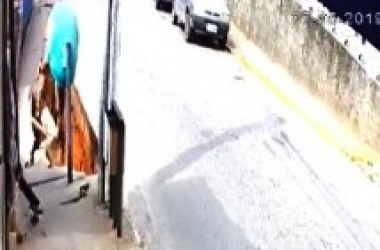 A imagem do vídeo mostra o momento exato em que a calçada começa a desmoronar, sob um orelhão (Reprodução da web)