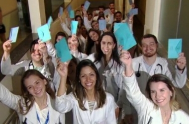Estudantes de medicina com cartas do projeto de 