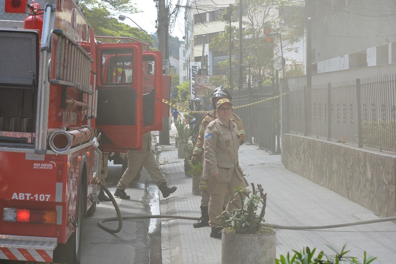 Os bombeiros atuando na entrada do prédio, na Comte Bittencourt (Foto: Henrique Pinheiro)