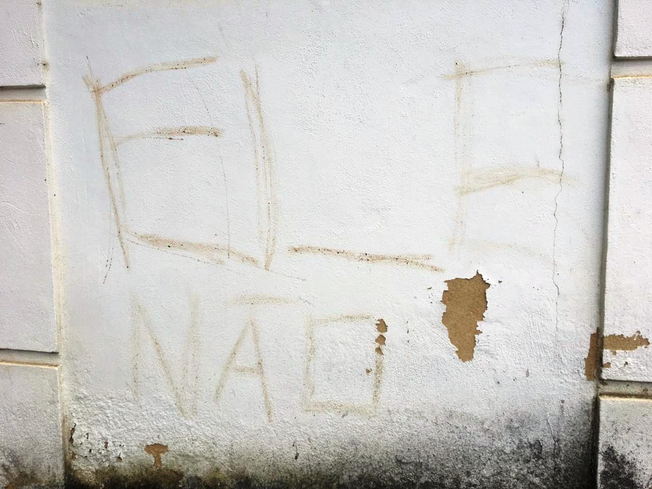 A hashtag #elenao riscada em um muro do distrito de São Pedro (Fotos divulgadas pela Polícia Civil)