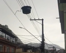 Ventania faz caixa d’água voar e parar em fios da rede elétrica